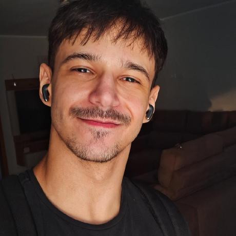 foto de Rodolfo Rerigan sorrindo usando uma camiseta preta, com um sofá atrás